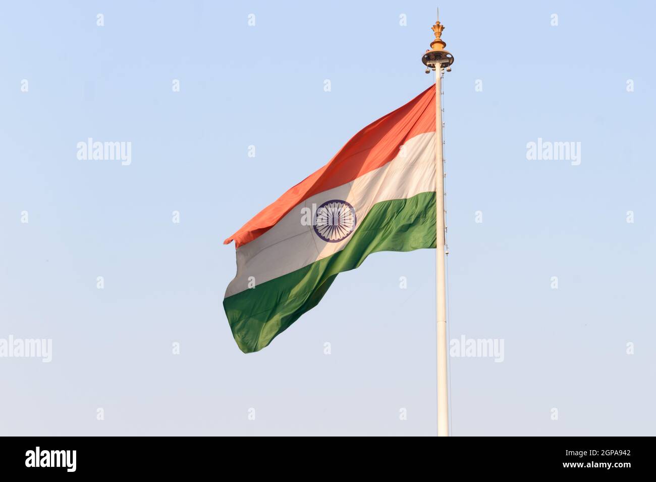Indian flag flying against blue sky background. The National Flag of India is a horizontal rectangular tricolor (saffron, white and green color) with Stock Photo