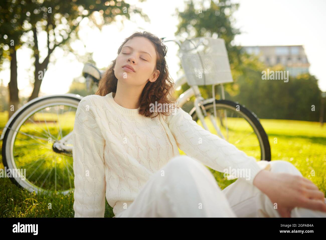 A girl sitting with her eyes closed and looking relaxed Stock Photo - Alamy