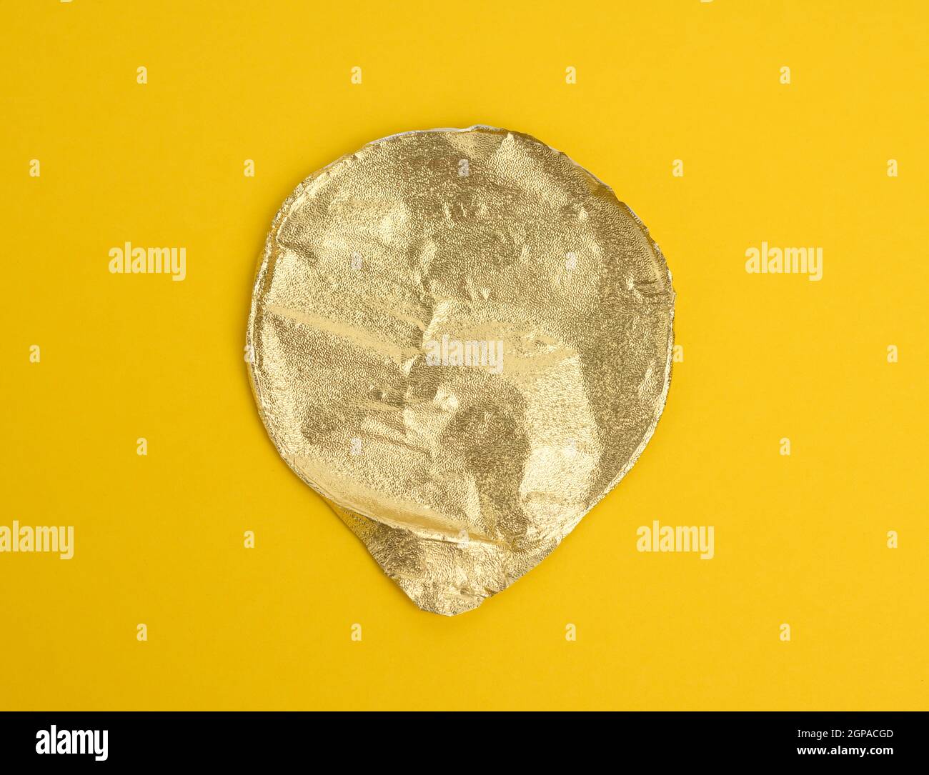 round golden aluminum thin lid for plastic yogurt jars on a yellow