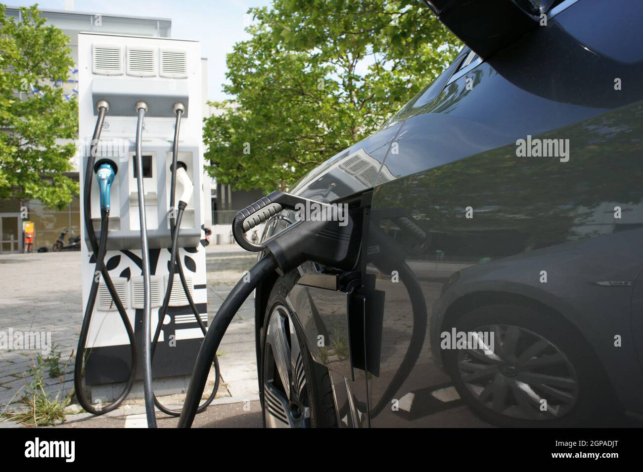 Electric car charges battery e-mobility on charging station Stock Photo