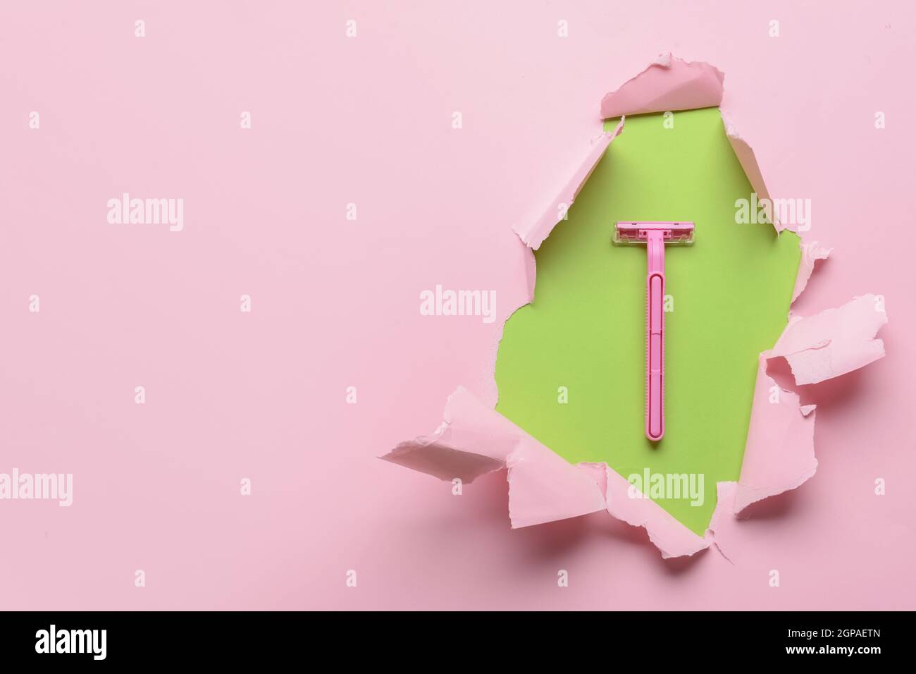 Safety razor visible through torn color paper Stock Photo Alamy