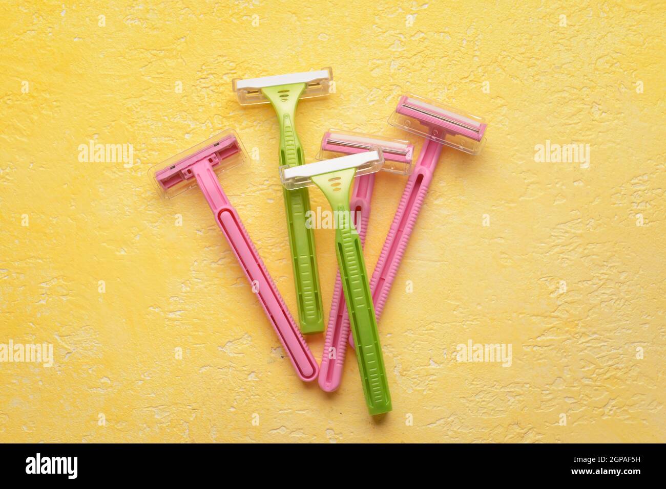 Many different razors for depilation on yellow background Stock Photo