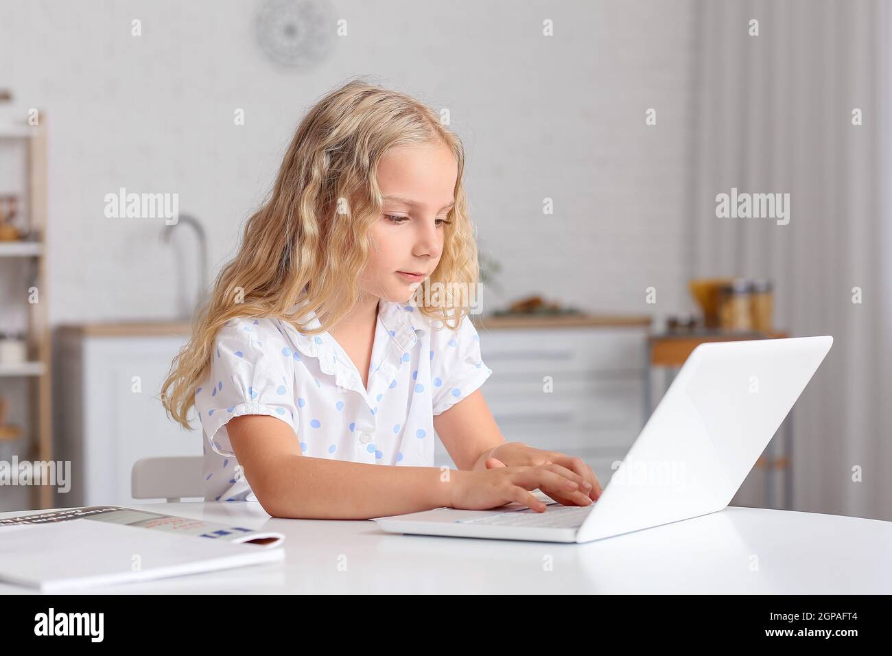 Cute little girl with laptop at home Stock Photo - Alamy