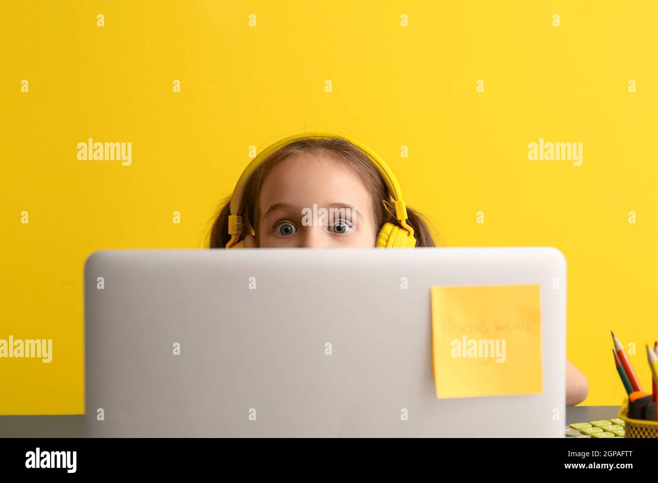 Little girl with laptop on color background Stock Photo - Alamy