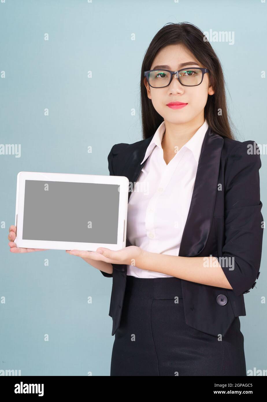 Young asian women in suit holding her digital tablet standing against ...