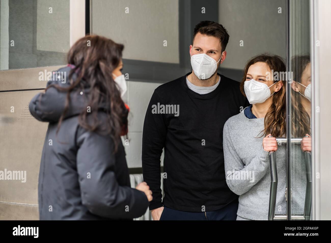 Neighbor Helping Hand And Assistance In Face Mask Stock Photo