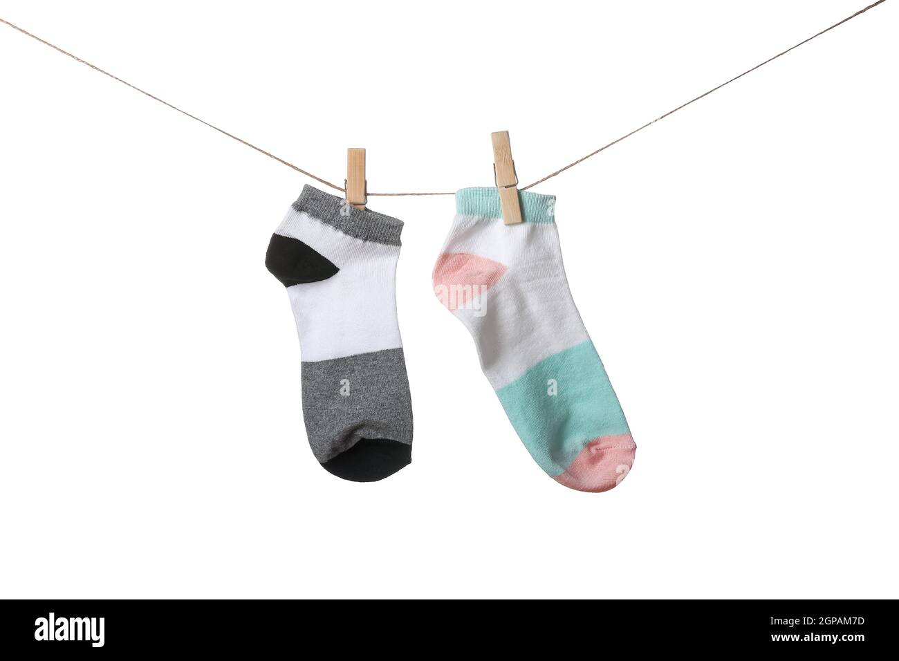 Two different socks hanging on rope against white background Stock ...