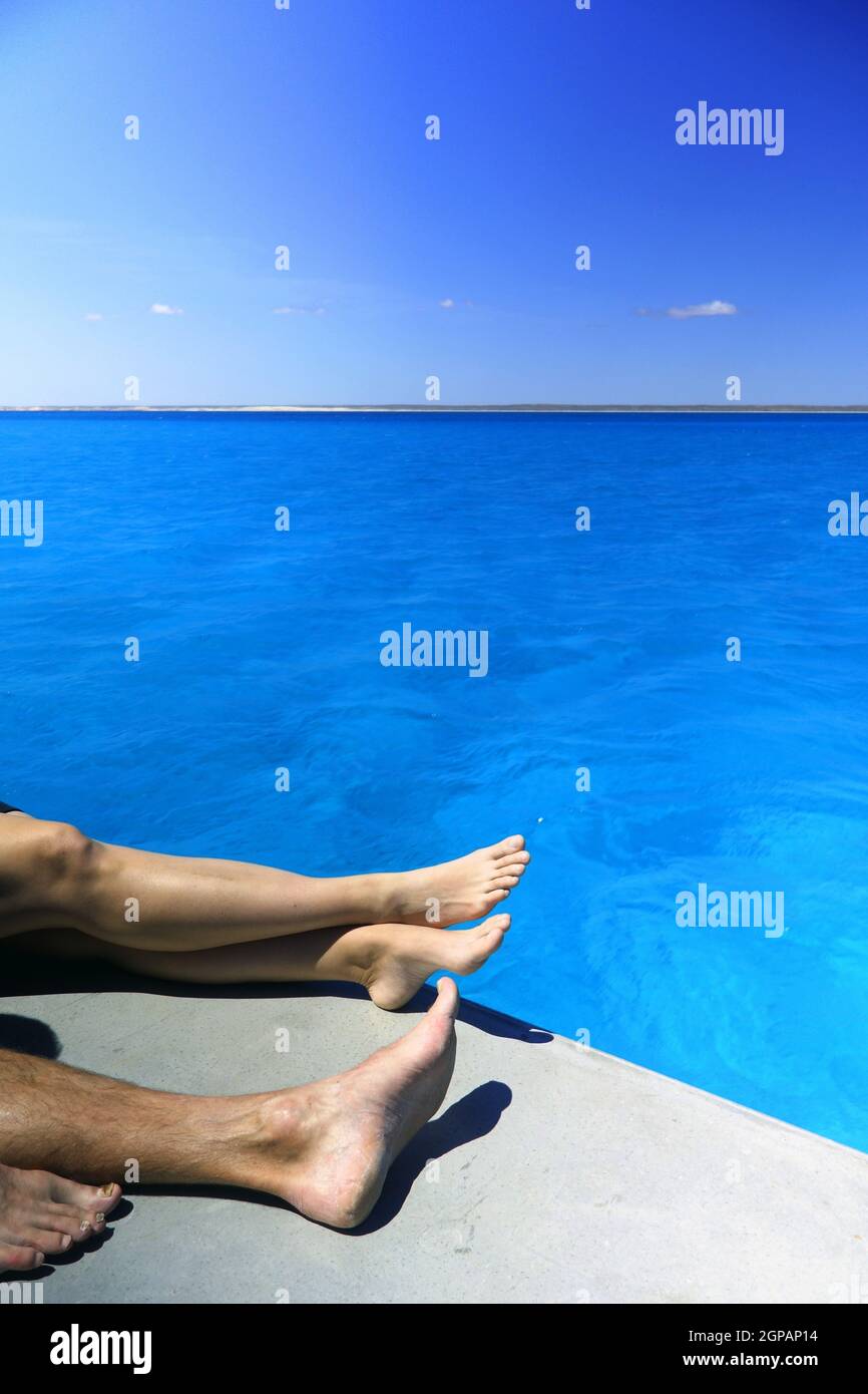 Legs of couple relaxing on sundeck of boat, lagoon of Ningaloo Reef Marine Park, Western Australia. No MR Stock Photo
