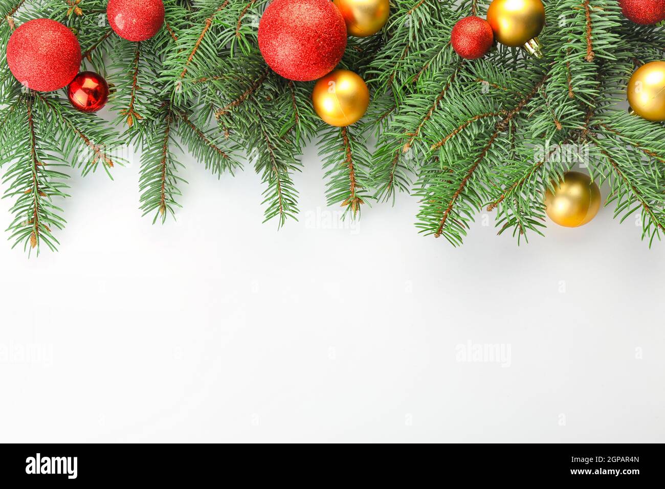 Fir branches with Christmas balls on white background Stock Photo - Alamy