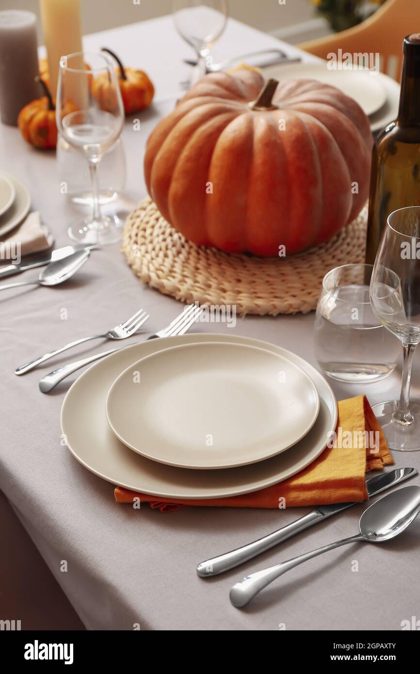 Autumn table setting with fresh pumpkin in room Stock Photo - Alamy
