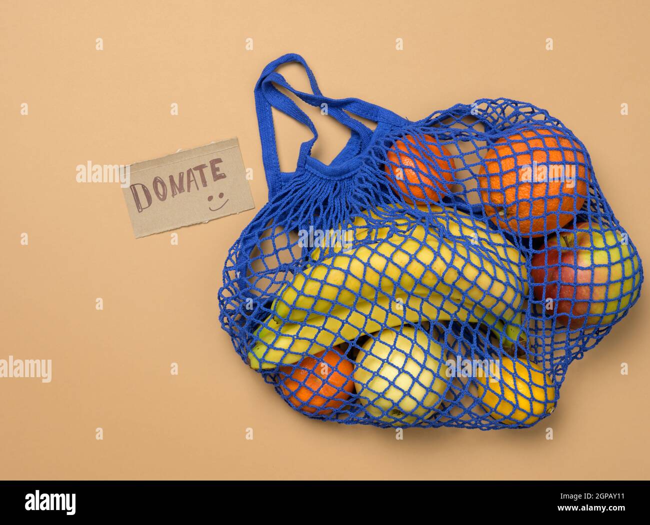 ripe fresh fruits in a textile string bag on a brown background, donating Stock Photo Alamy