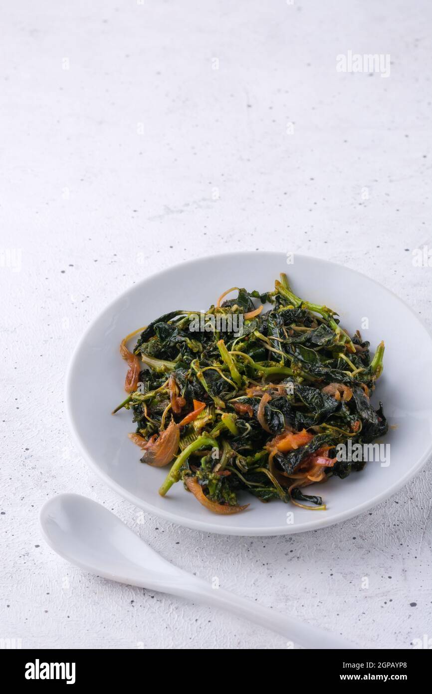 amaranthus or amaranth dish, healthy green leafy vegetarian curry dish with a spoon on a white textured surface Stock Photo