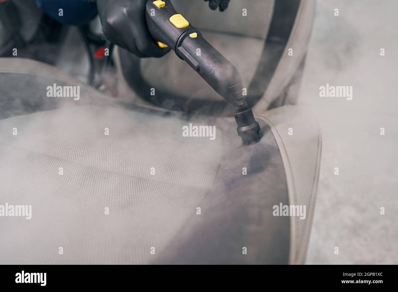 Steam cleaning of automobile seats in car service with vapor steamer