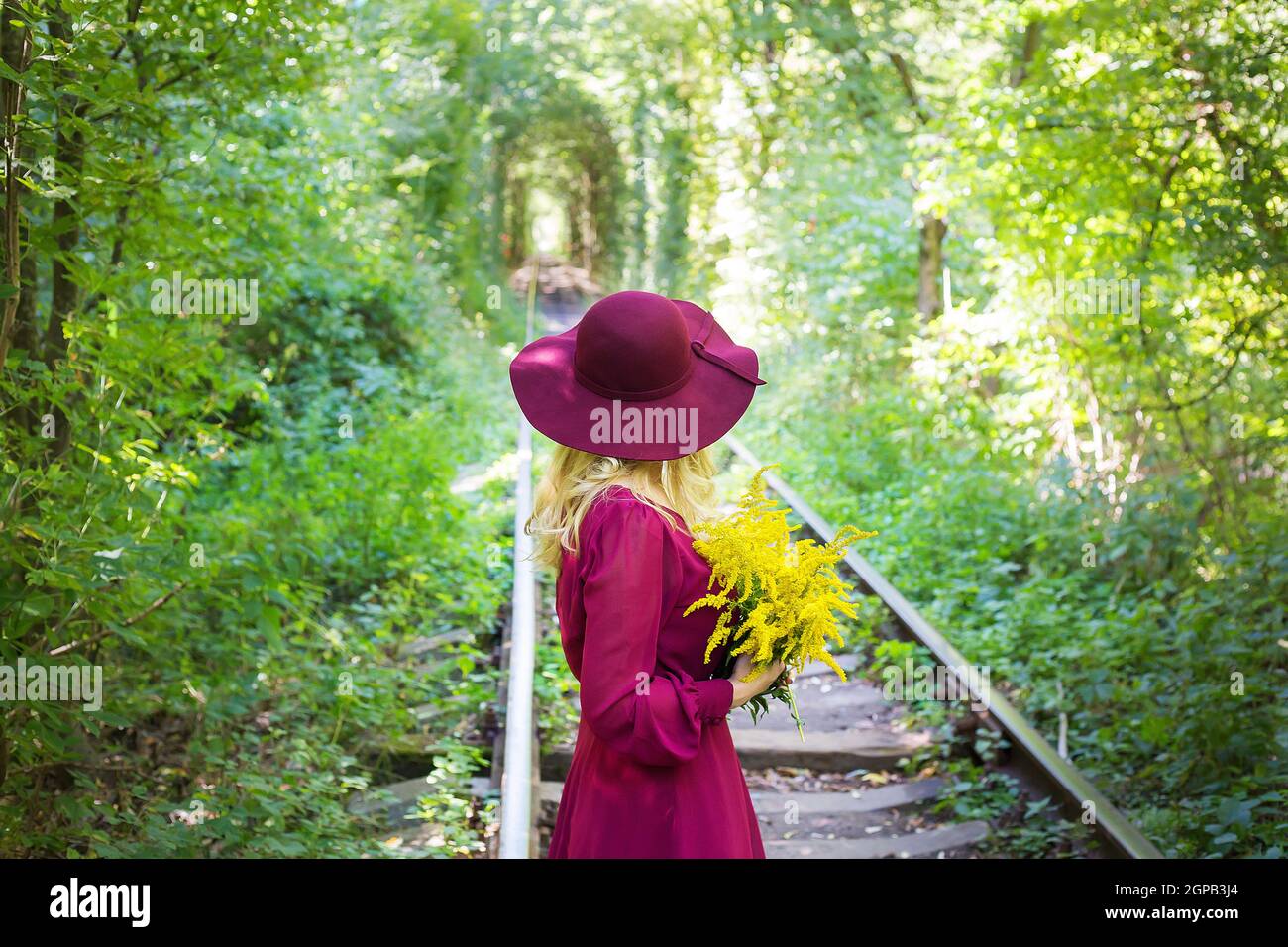 girl in a hat with a bouquet of yellow flowers Stock Photo - Alamy