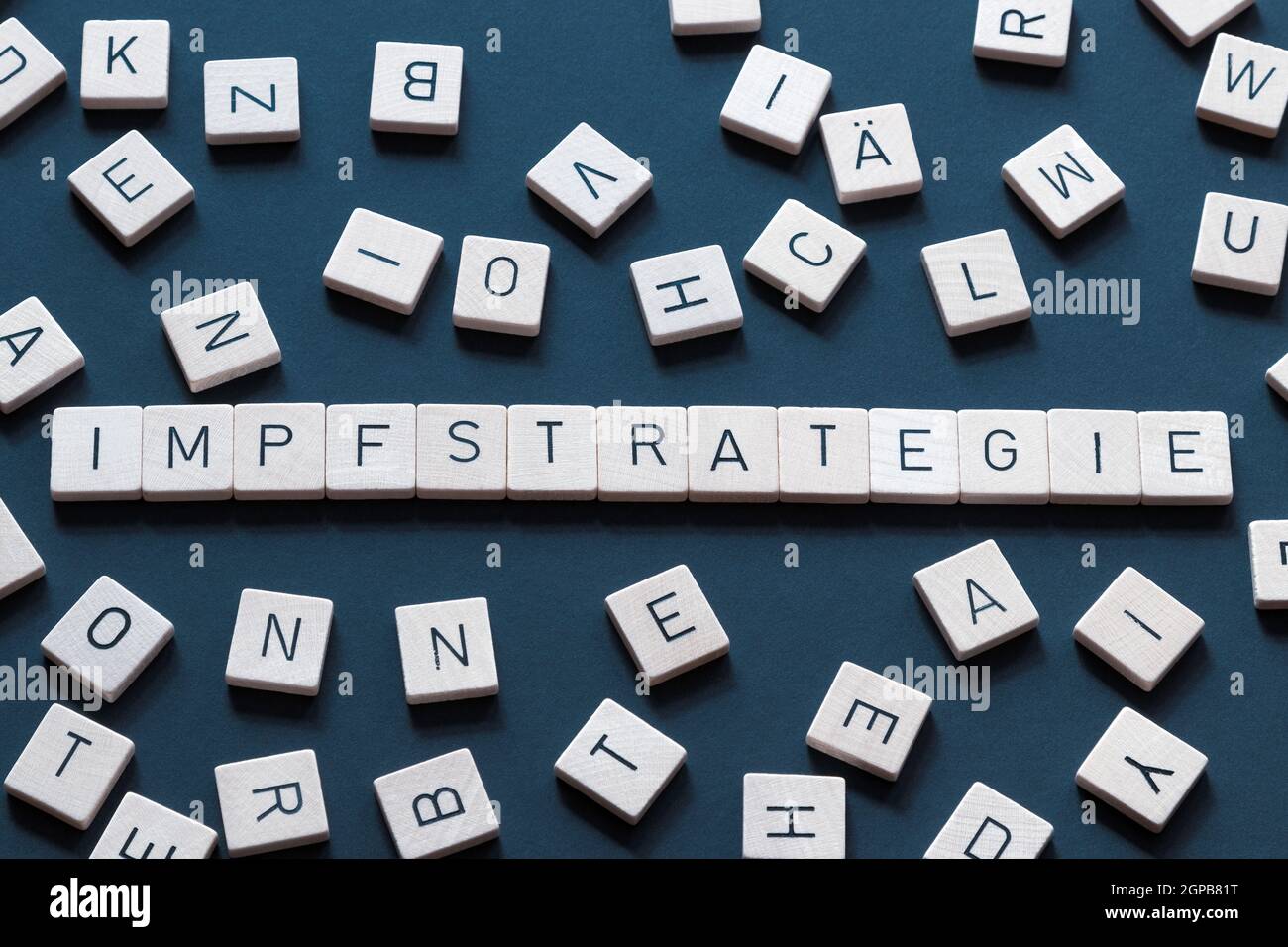 Vaccine strategy in german 'Impfstrategie' the word stands for organization and smooth operation. Word and letters on blue background. Germany Stock Photo