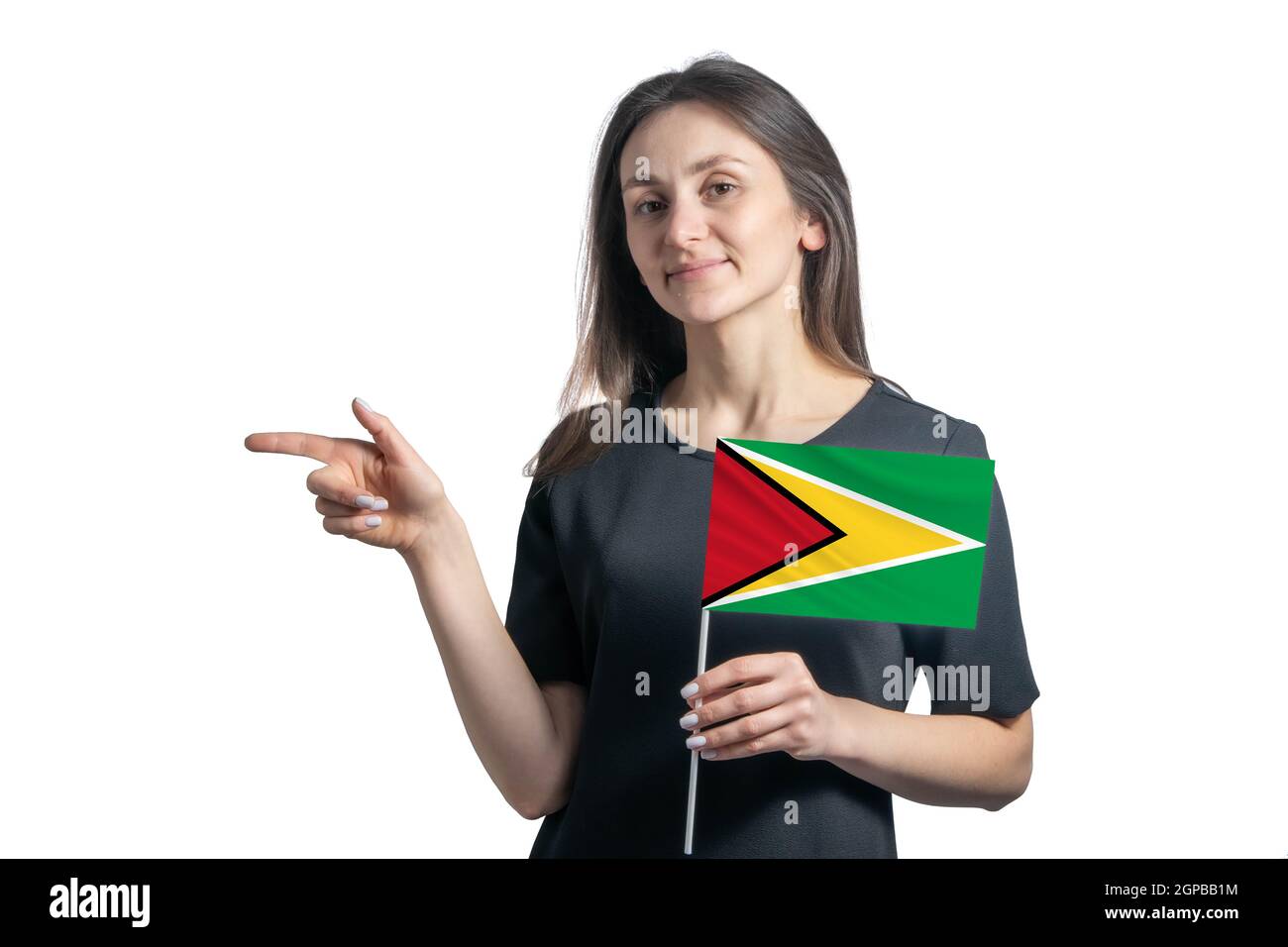 Happy young white woman holding flag Guyana and points to the left isolated on a white background. Stock Photo