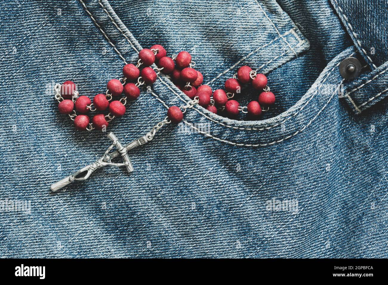 Catholic rosary in the pocket of the denim jeans Stock Photo Alamy