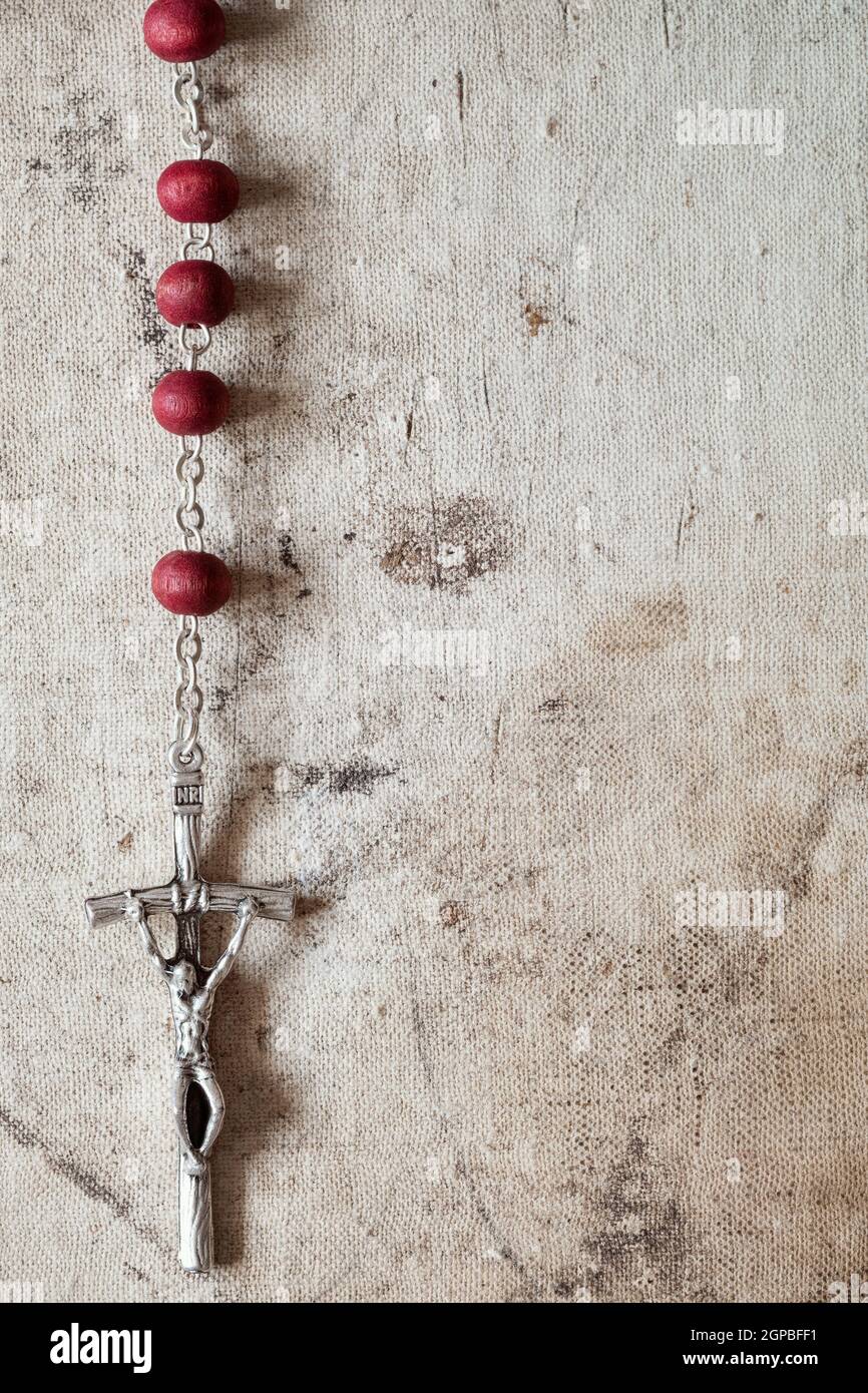 Catholic rosary hanging on old canvas background. Copy-space Stock
