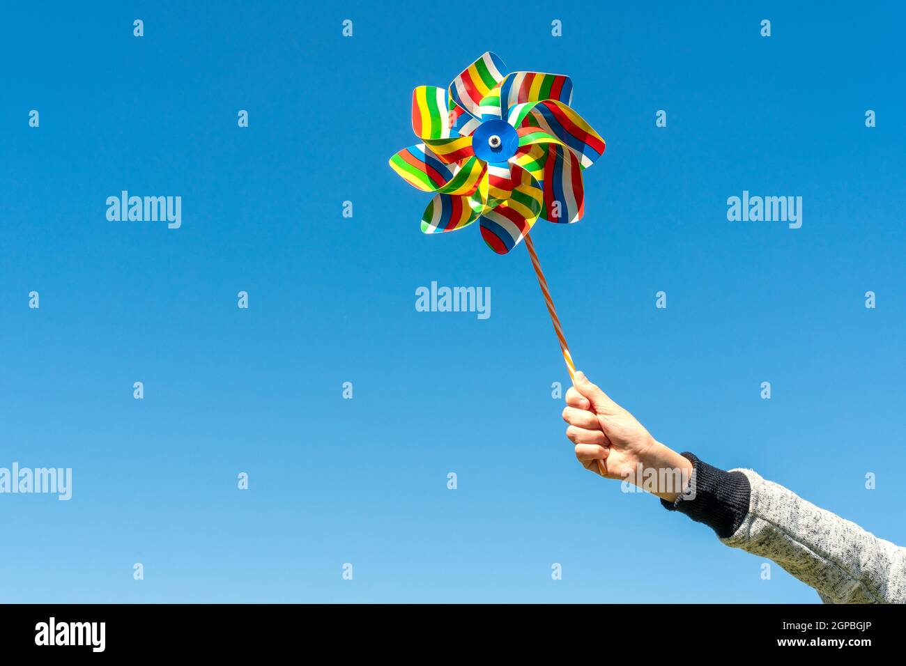 Pinwheel Hand Child's hand with colorful pinwheel on blue sky background Stock Photo ...