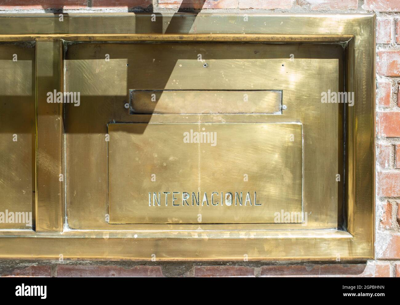 Post office golden brass mailbox. Engraved word in Spanish