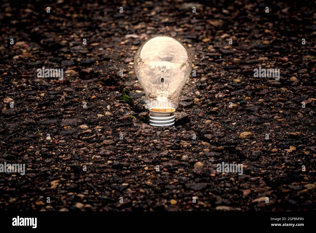 Old light bulb glowing in dark. Ideas and inspiration concept Stock