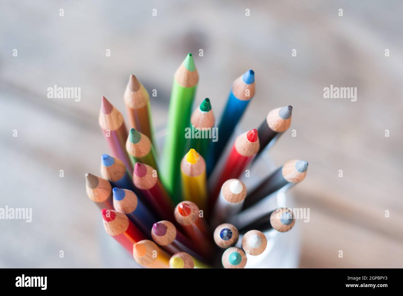 Colored pencils in a can on rustic wooden table Stock Photo