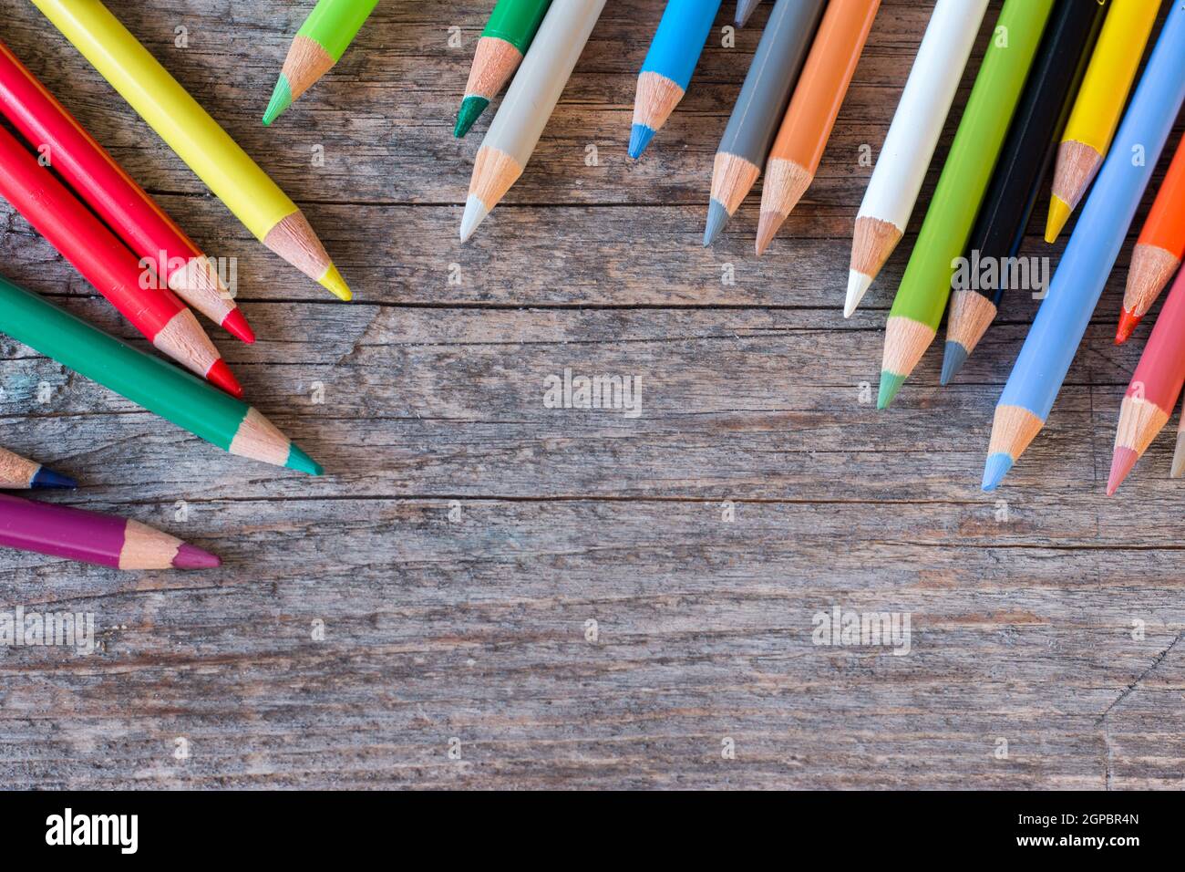 Set of multi-colored pencils on a rustically wooden table, copy space ...