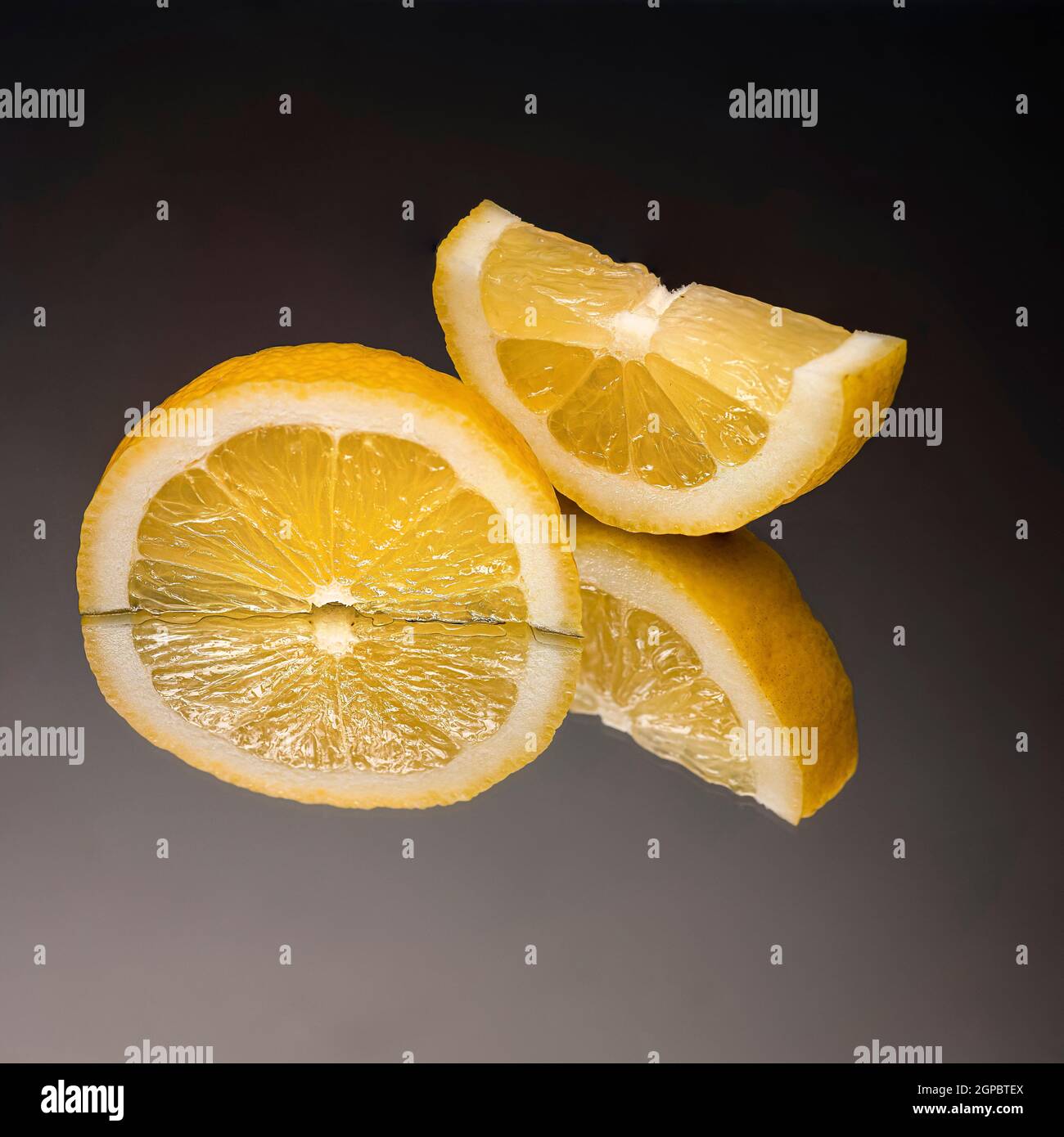 a sliced lemon on a mirror with the black background Stock Photo Alamy