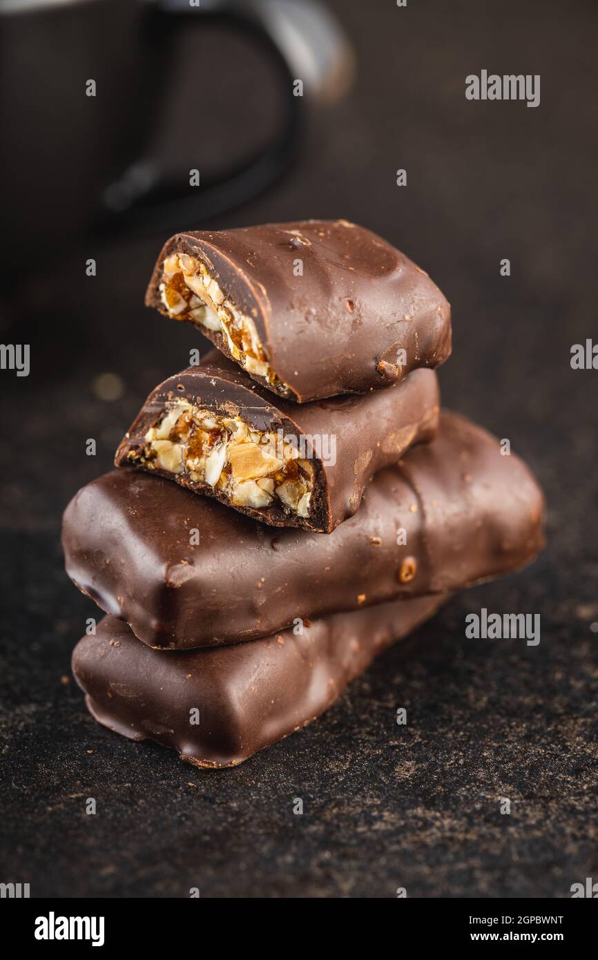 Chocolate bars with nuts filling on black table Stock Photo - Alamy