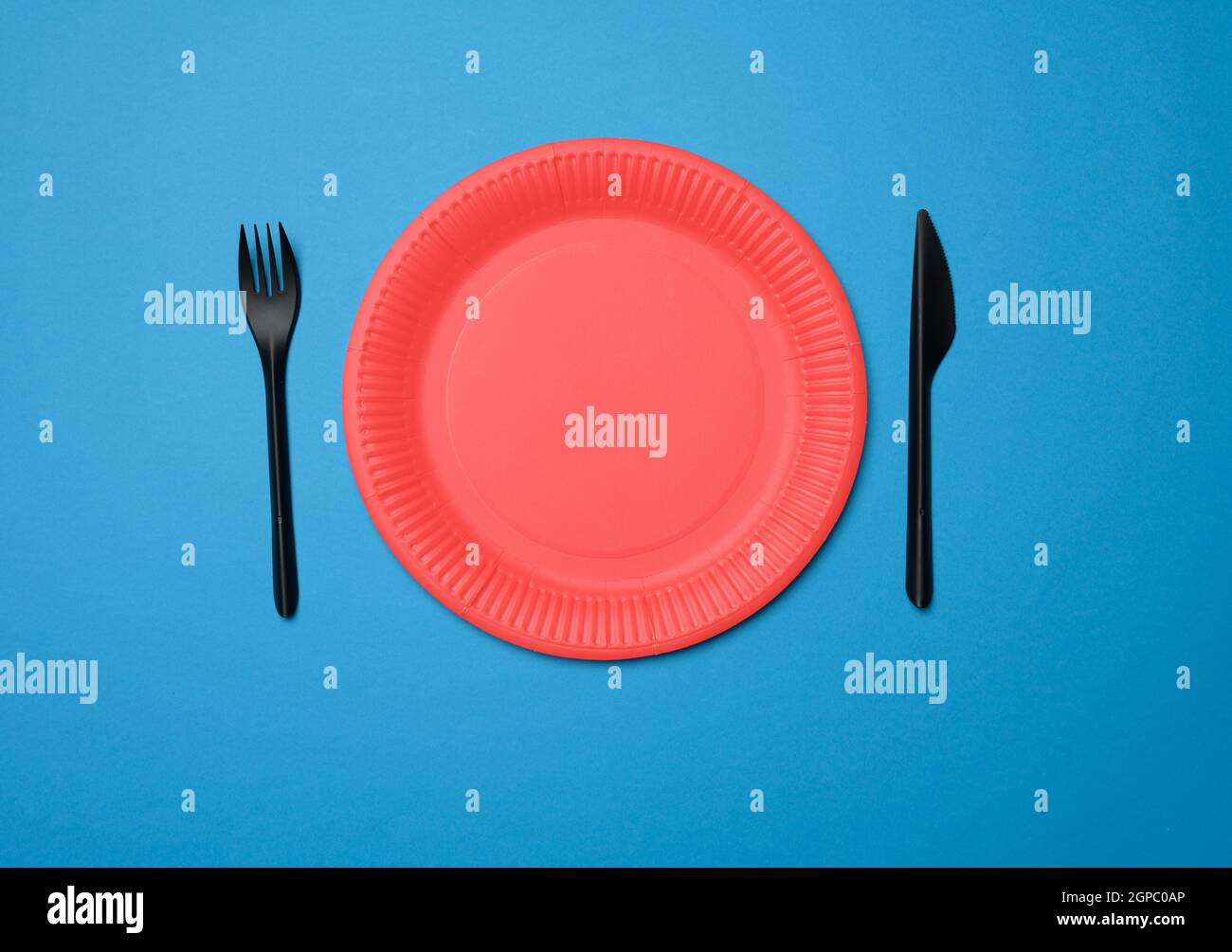 empty red paper disposable plates on a blue background, top view Stock Photo