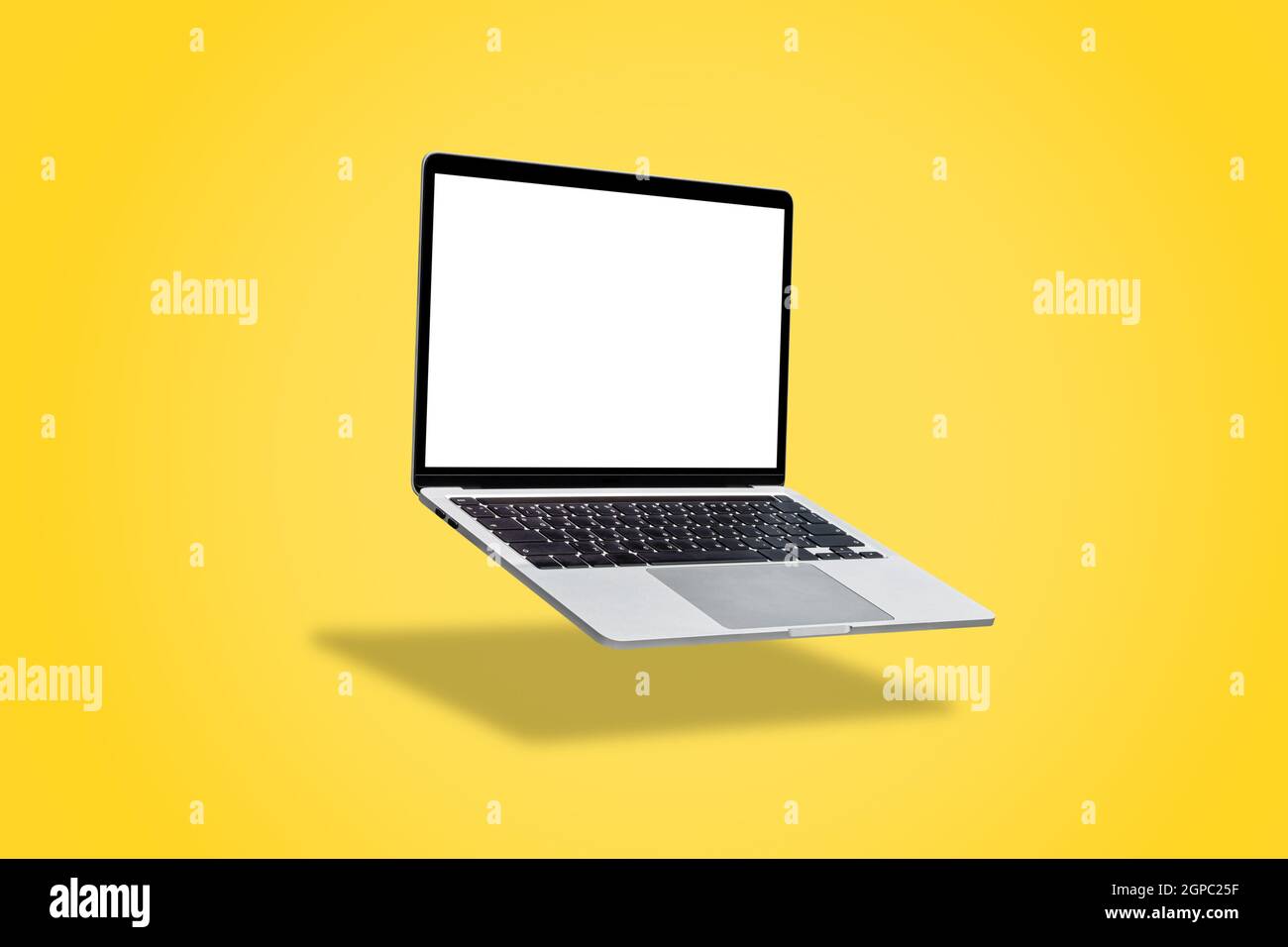 Laptop computer with blank screen, floating on a yellow background. Stock Photo