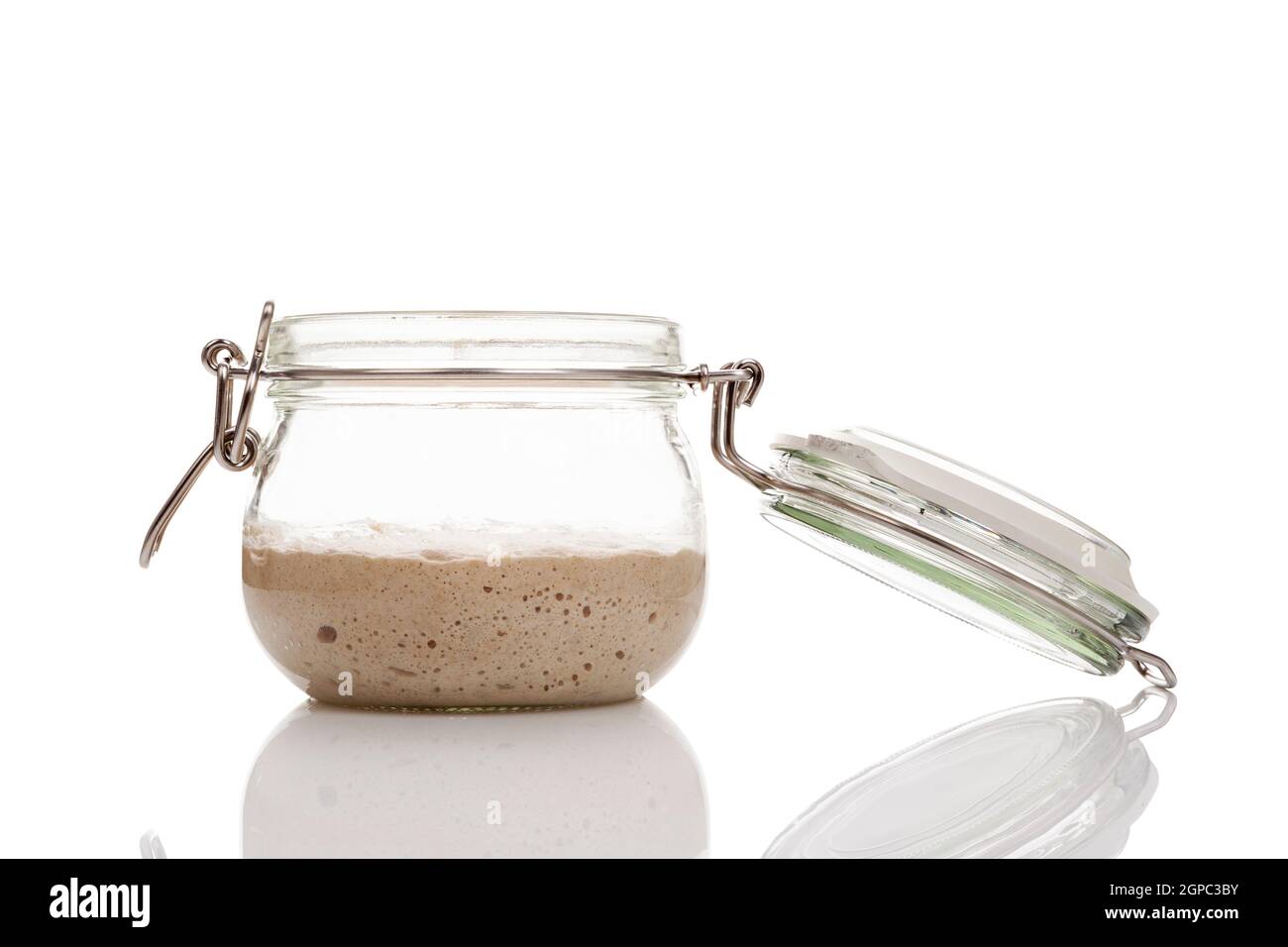 Home made starter yeast growing in a glass jar isolated on white