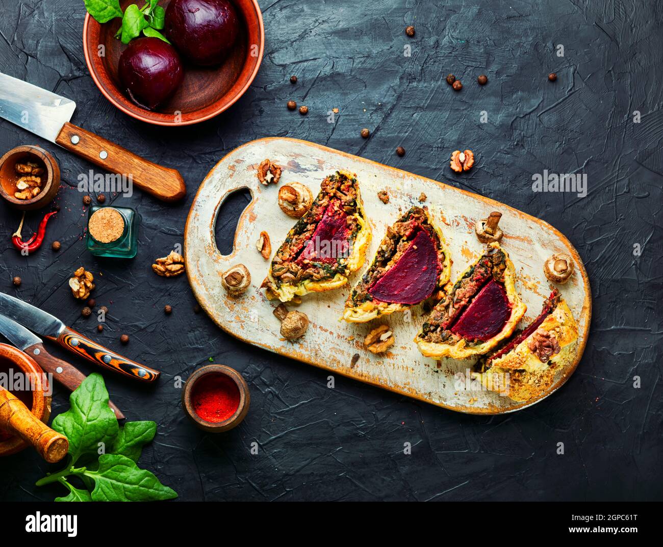 Delicious beetroot pie sliced on a kitchen board.Sliced pie Wellington ...