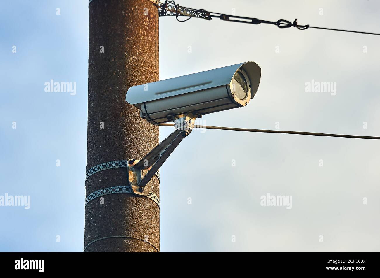 A security camera is hanging on a concrete post Stock Photo - Alamy