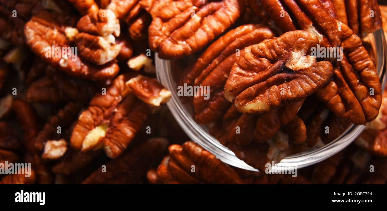 Composition with a bowl of shelled pecan nuts. Delicacies Stock Photo