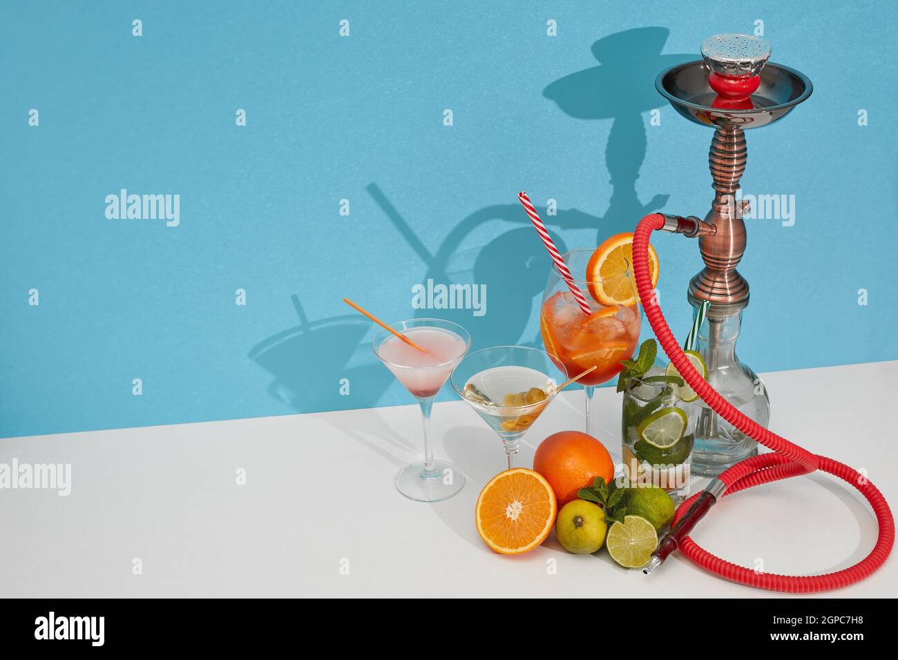 Cocktails set. Hookah (shisha) and glasses with various cold beverages standing on double white