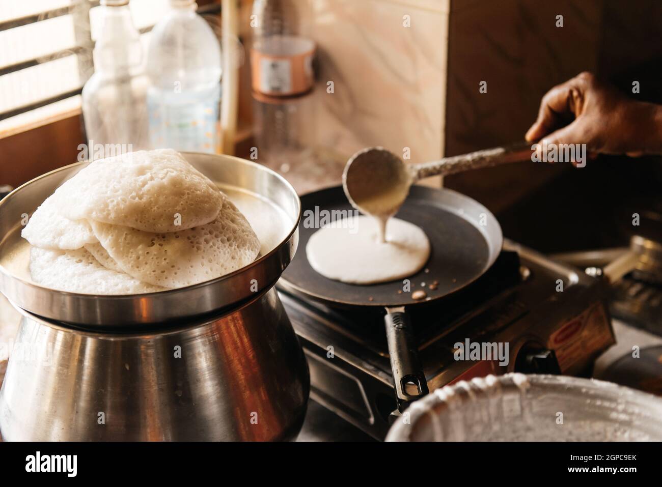 Idli or idly, savory rice cake from India, breakfast foods on South. Woman cooking at home, hot food with steam Stock Photo