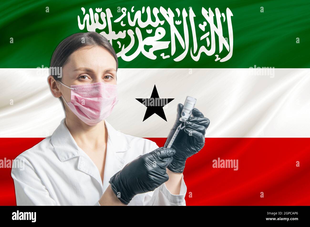 Girl doctor prepares vaccination against the background of the Somaliland flag. Vaccination concept Somaliland. Stock Photo