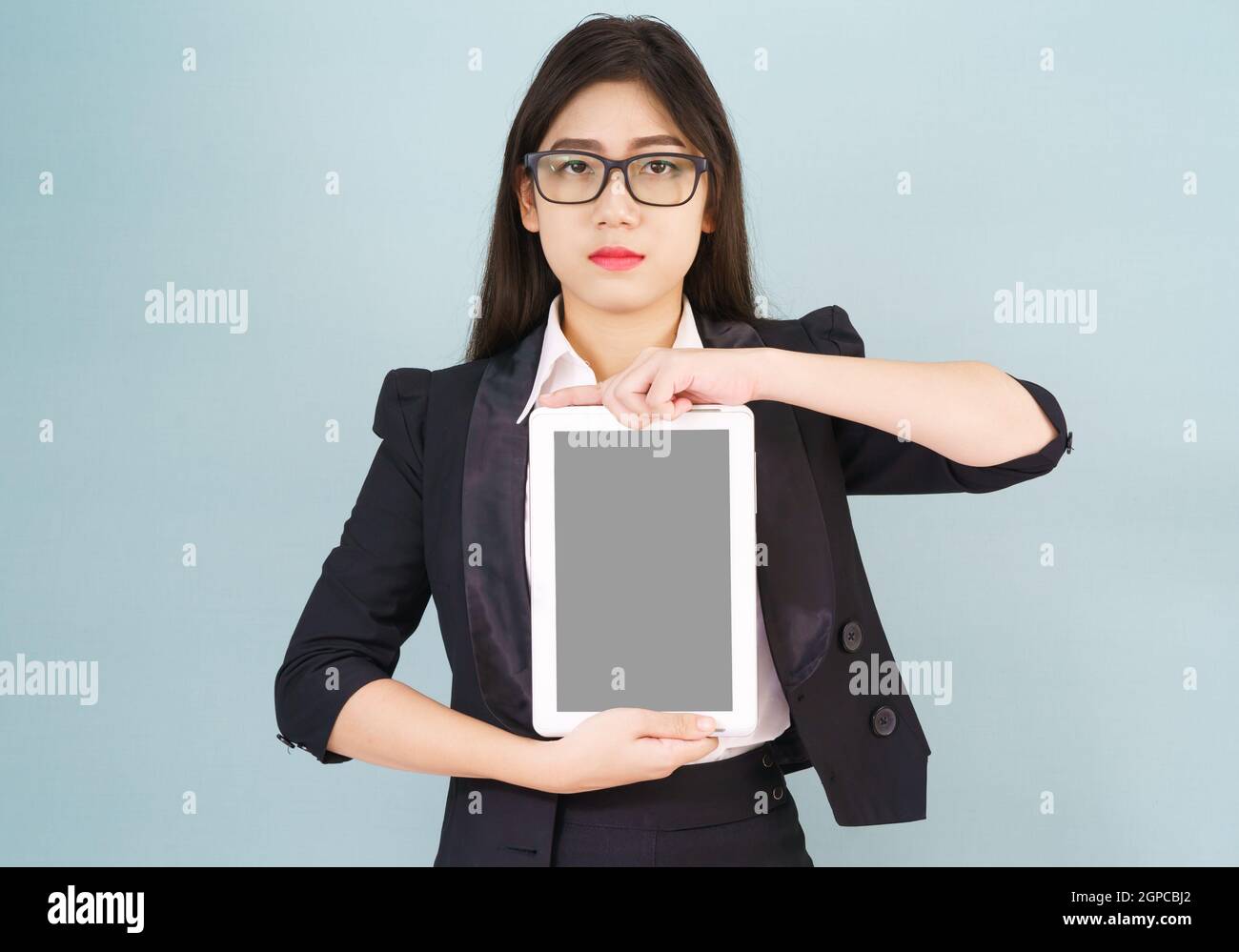 Young asian women in suit holding her digital tablet standing against ...