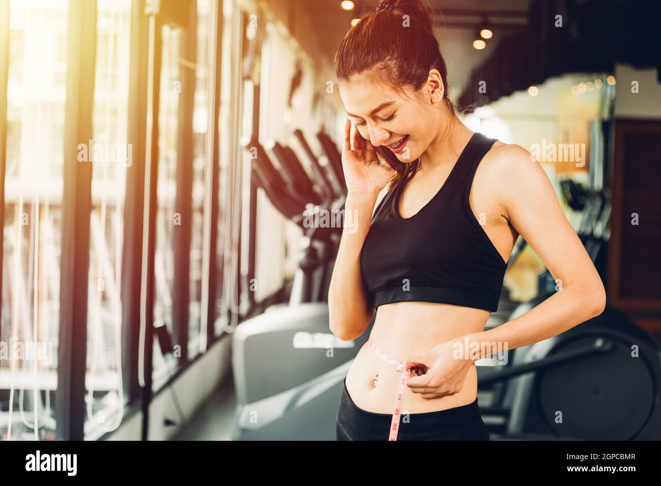 Happy asian beautiful woman have body shape slim by centimeter tape at  fitness gym Stock Photo - Alamy