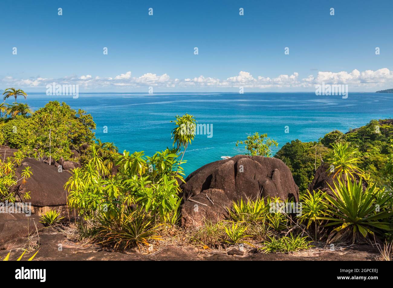 View from Anse Major Nature Trail over the northwest coastline of Mahe island and granite rock in the foreground, Seychelles Stock Photo