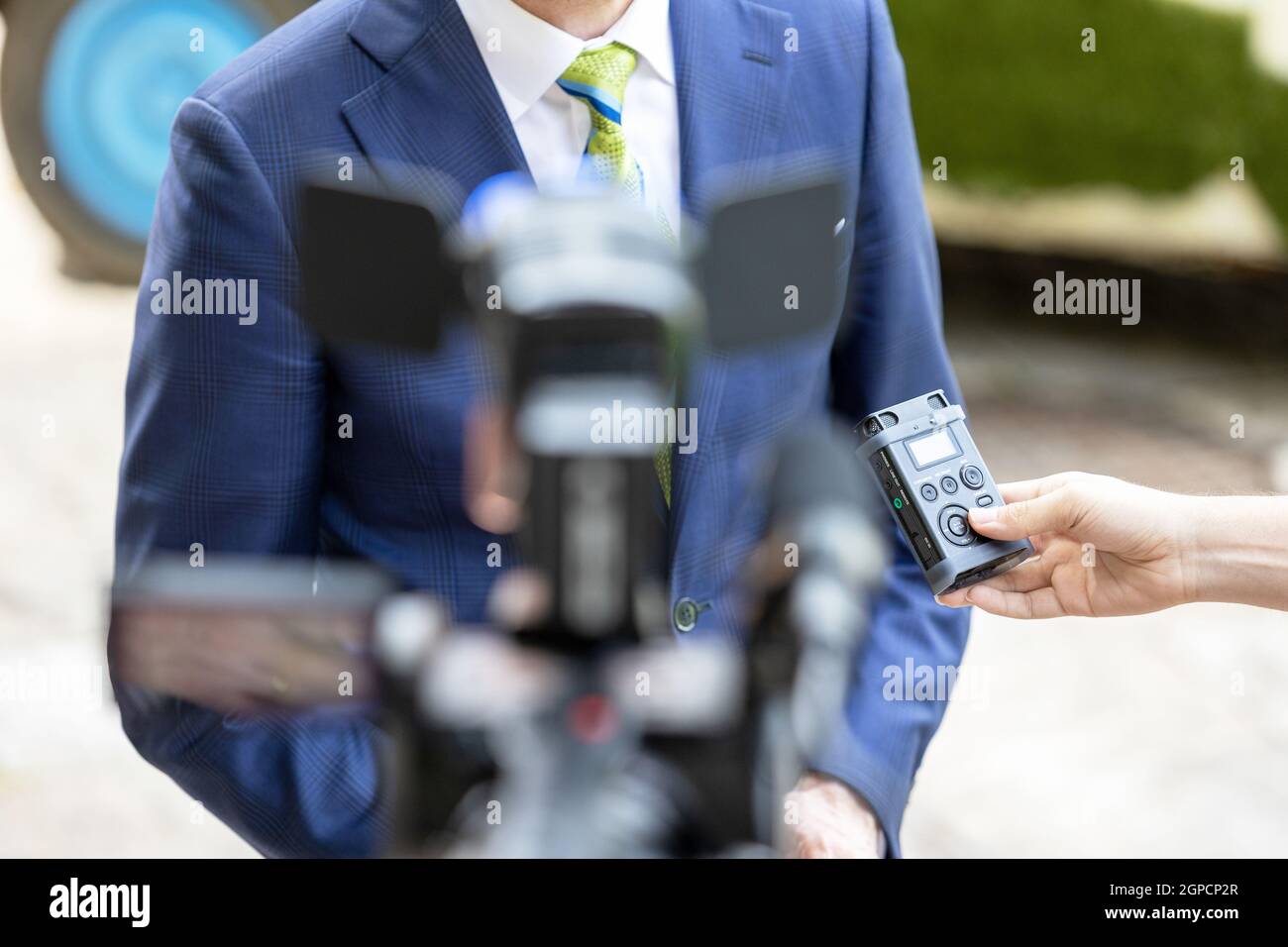 Reporter holding voice recorder making media interview with politician ...