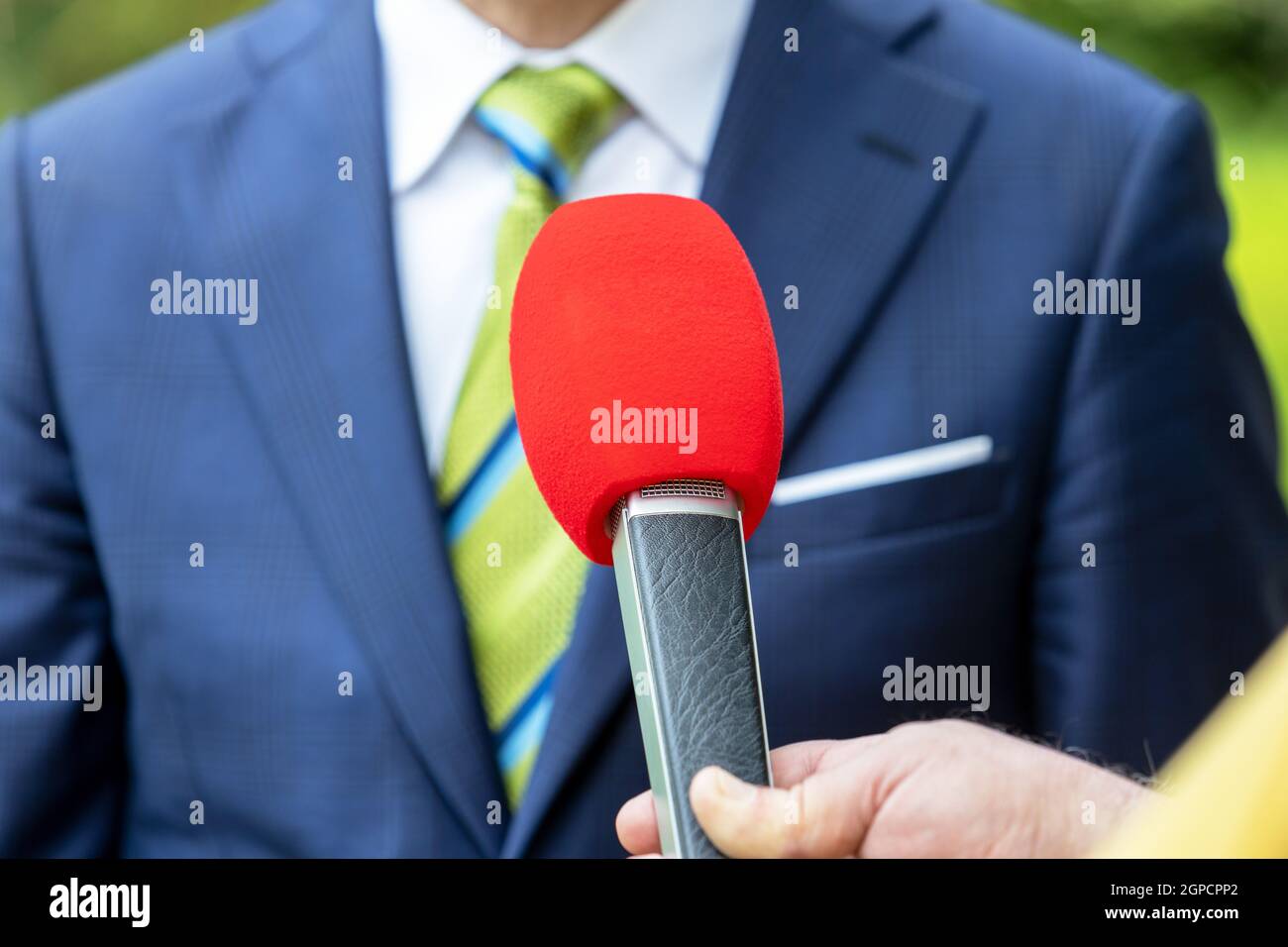 Reporter holding microphone making media interview with politician or ...