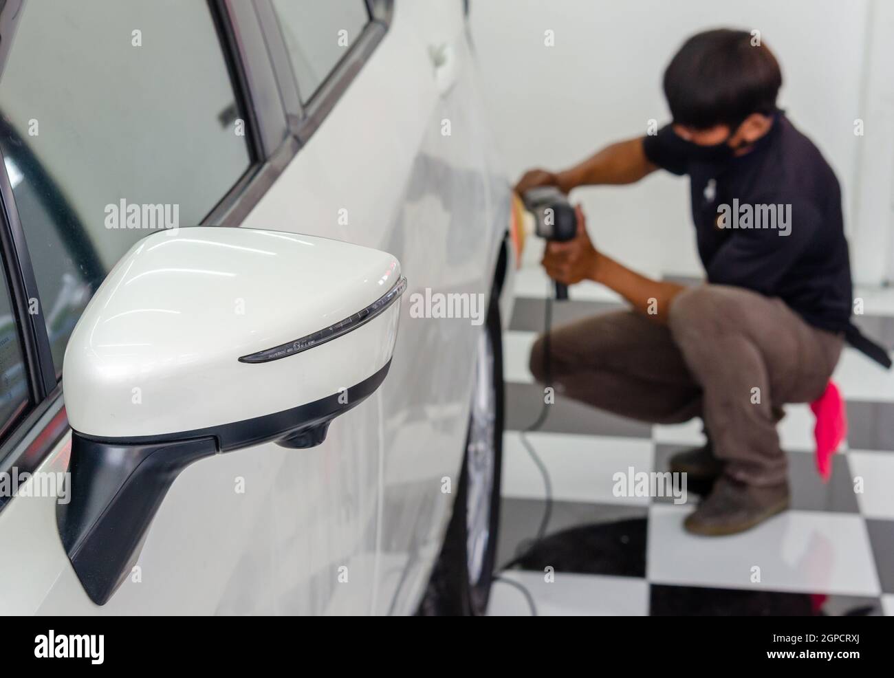 Man hand holding a car polish machine. Car detailing Buffing and wax