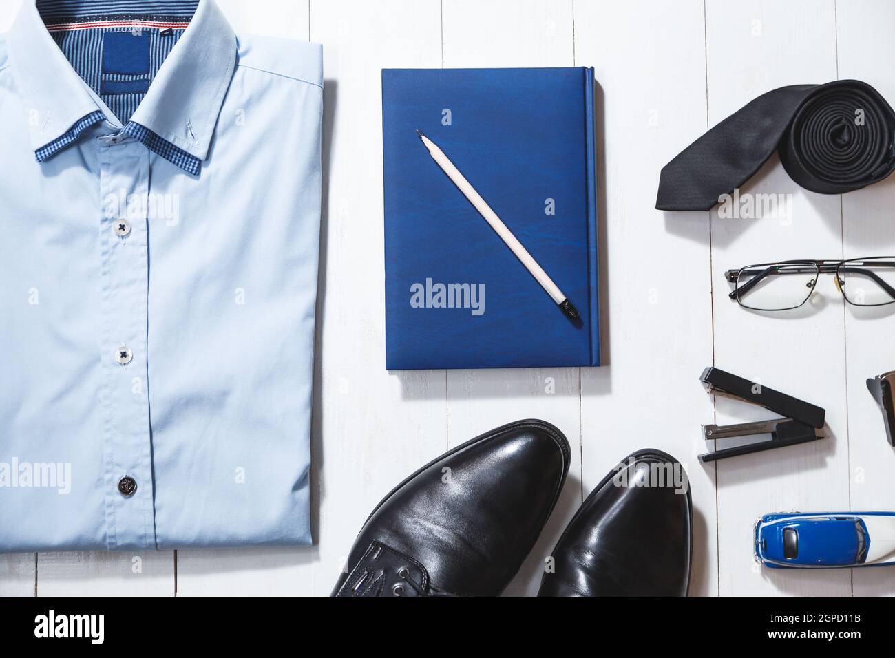 Fashion set of businessman accessories, top view on white wooden