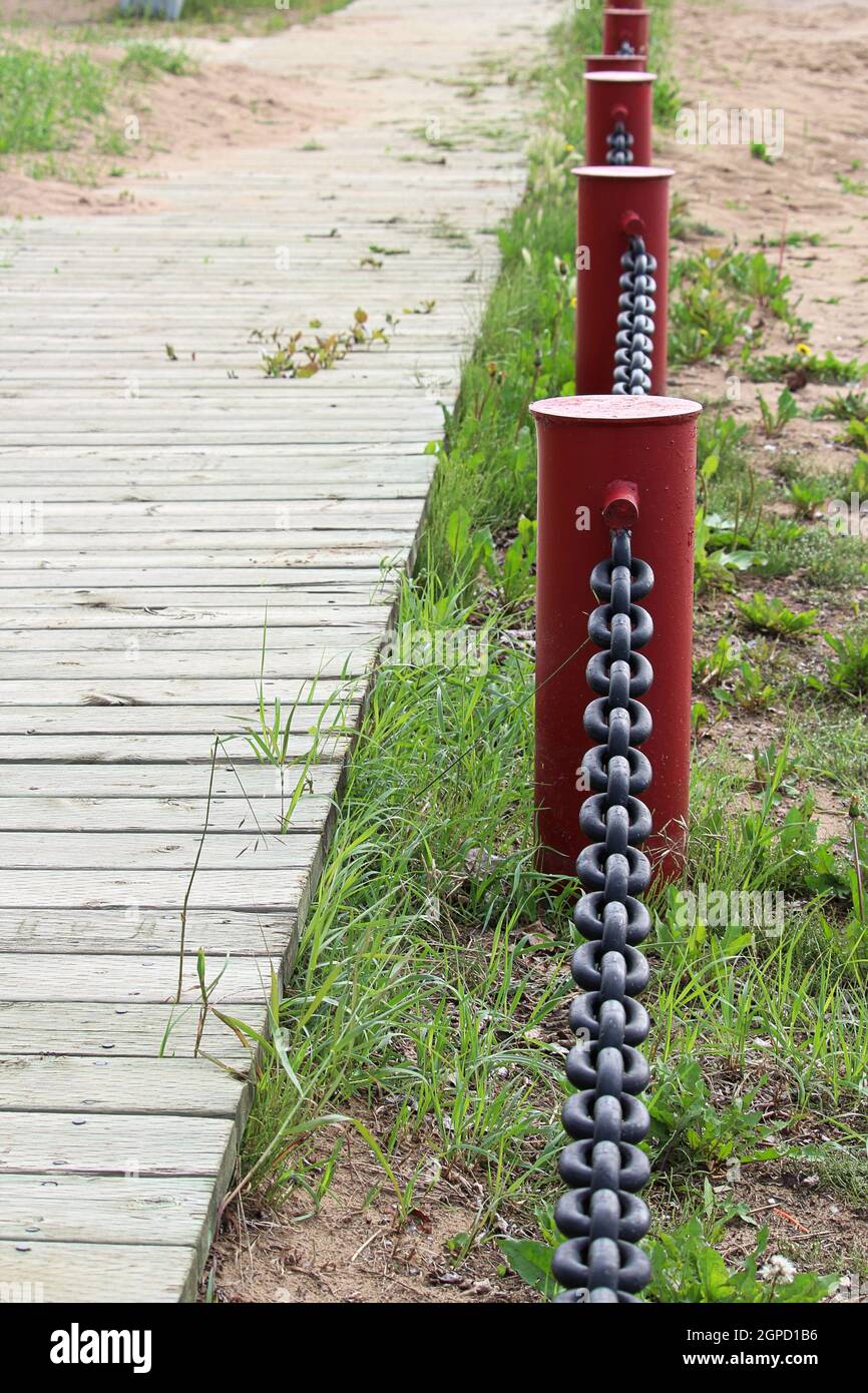 Vertical of a chain link fence beside a boardwalk Stock Photo - Alamy