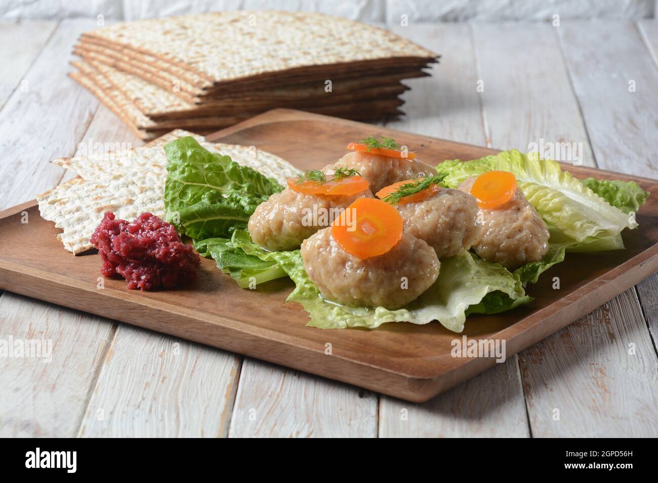 Passover traditional Jewish food- gefilte fish with carrots, lettuce, horse radish and matzah. Passover celebration concept Stock Photo