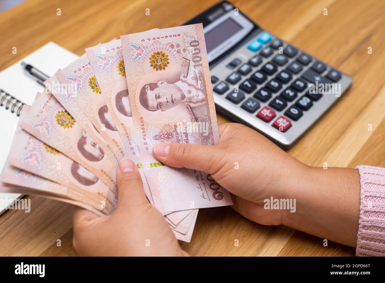 Close up of asian woman with calculator counting money.Woman calculate the spending at home. Stock Photo