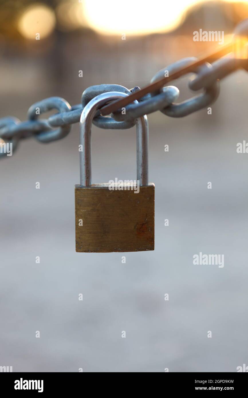 Closed padlock hanging from a thick chain Stock Photo