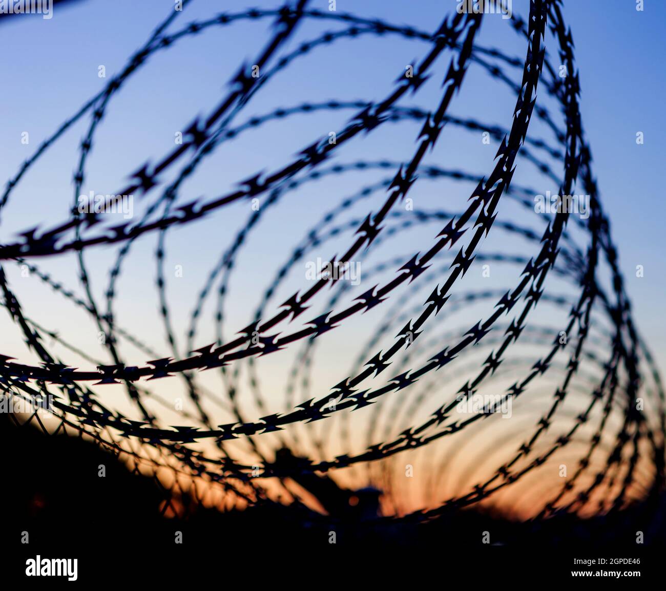 Fence with a barbed wire under a blue sky Stock Photo - Alamy